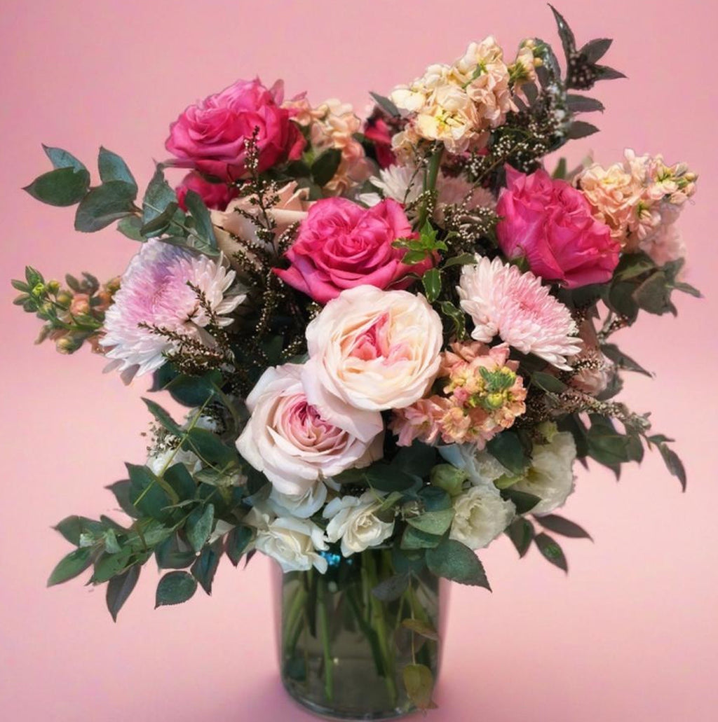 a full image of a pink&peach garden-style floral arrangement in a vase